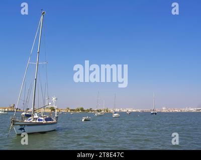 Kleine Boote vor Anker in der Bucht von Seixal mit Blick auf die Stadt Barreiro am Horizont. Seixal, Setubal, Portugal Stockfoto