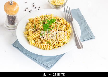 Fusilli Pasta garniert mit Basilikum, Chilli-Flocken und Kräutern Stockfoto