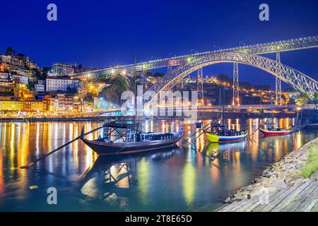 Die Skyline der Altstadt von Porto, Portugal, am Fluss Douro mit Ragelobooten bei Nacht. Stockfoto