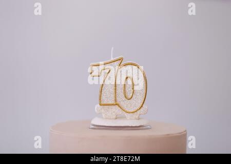 Detail der Zahl siebzig oben auf dem Geburtstagskuchen, 70 Geburtstag, weißer Kuchen, 70 Jahre alte Geburtstagskuchen Kerze Stockfoto