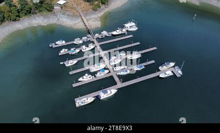 Segelboot, Motorboote, Dock und kleine Insel. Kleiner Hafen von oben. Aus der Luft. Dron-Ansicht Stockfoto