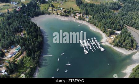 Segelboot, Motorboote, Dock und kleine Insel. Kleiner Hafen von oben. Aus der Luft. Dron-Ansicht Stockfoto