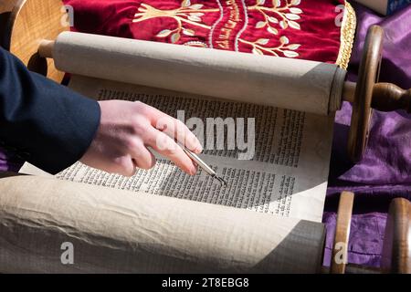 Nahaufnahme einer Hand mit einem yad oder Zeiger während des Lesens der Thora während eines jüdischen Gebetsgottesdienstes. Stockfoto