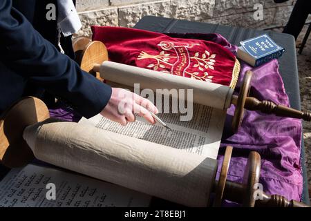 Nahaufnahme einer Hand mit einem yad oder Zeiger während des Lesens der Thora während eines jüdischen Gebetsgottesdienstes. Stockfoto