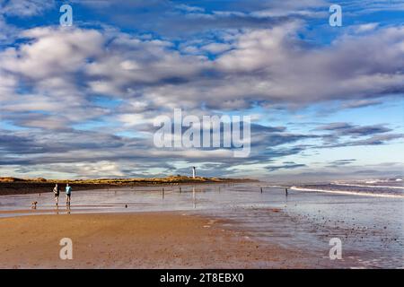 Lossiemouth Moray Coast Schottland der Weststrand ein Novemberhimmel und Meer und Läufer auf dem Sand Stockfoto