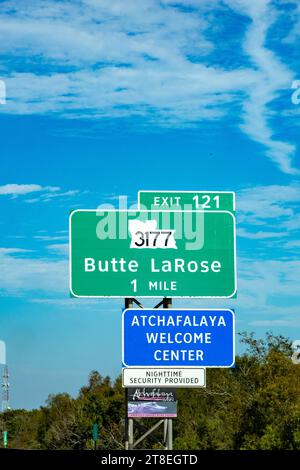 Atchafalaya, USA - 23. Oktober 2023: Beschilderung zum Atchafalaya Welcome Center in 1,5 km am Highway mit Sicherheitsdienst bei Nacht und Alligator auf dem Schild Stockfoto