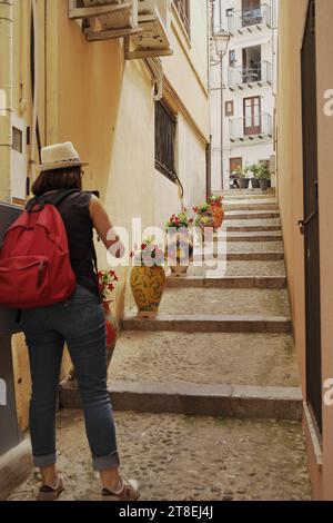 Blick auf eine Gasse mit Stufen und bunten Blumentöpfen in Cefalu, Sizilien, Italien Stockfoto