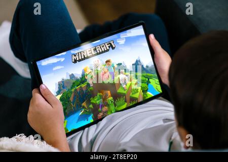 Kleiner Junge, der Minecraft-Spiel auf einem Tablet spielt. Minecraft ist ein sehr beliebtes Spiel bei Kindern und Jugendlichen. Rosario, Argentinien - 20. November 2023. Stockfoto
