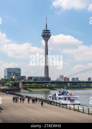 Düsseldorf, Deutschland - 2. Juni 2022: Blick entlang des Rheins mit dem Fernsehturm Rheinturm und Menschen an der Rheinpromenade in Düsseldorf, Nord-Rh Stockfoto