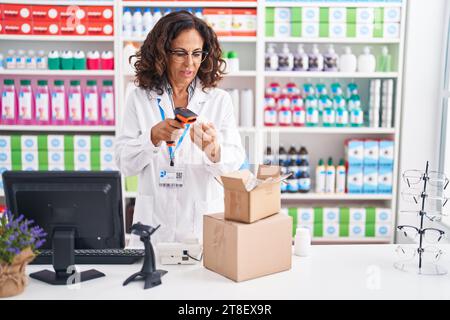 Frau mittleren Alters Apotheker Scannen Pillen Flasche in der Apotheke Stockfoto