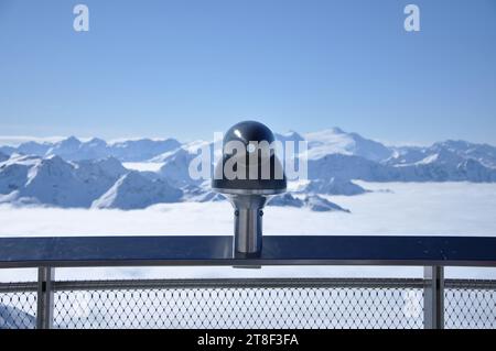 Das Fernglas des Landschaftsteleskops zeigte in Richtung Berge. Schneebedeckte Alpen im Winter Stockfoto