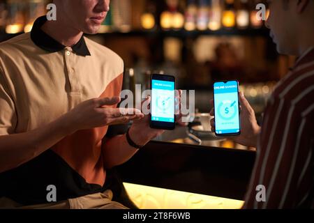 Unternehmer, der Geldtransfers vom Geschäftspartner akzeptiert, wenn er an der Bar sitzt Stockfoto