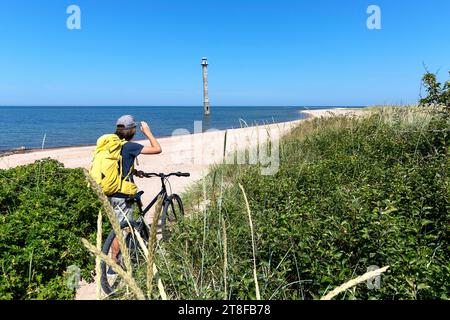 Ein kleiner Tourist auf einer Fahrradtour durch den malerischen Leuchtturm Kiipsaare an der Spitze der Harilaid-Halbinsel auf der Insel Saaremaa, Estland Stockfoto