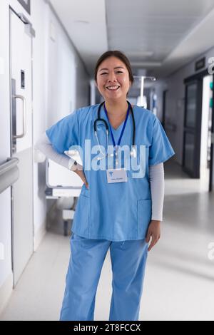 Porträt einer glücklichen asiatischen Ärztin, die im Krankenhausflur steht Stockfoto