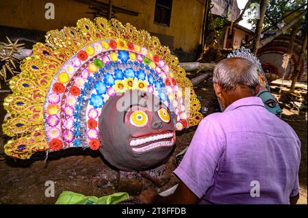 Ein Dorfidol-Künstler stellt große Farbmasken her, die Purulia Chhau Tanzmasken nachempfunden sind (Purulia Chhau Tanz ist auf der UNESCO-Liste der Tänze aufgeführt) von Göttinnen, Tieren und Rakshasas (humanoide Dämonen oder ungerechte Geister) wie hinduistische Mythologie-Charaktere aus Ton. Der Künstler malt dann mit Farbe und Verzierung die Tonmasken, die in einem Jagaddhatri Puja Pandal installiert werden. Dann tragen die Arbeiter die fertigen Masken in einem Auto in Tehatta, Westbengalen, Indien am 20.11.2023. (Foto: Soumyabrata Roy/NurPhoto) Stockfoto