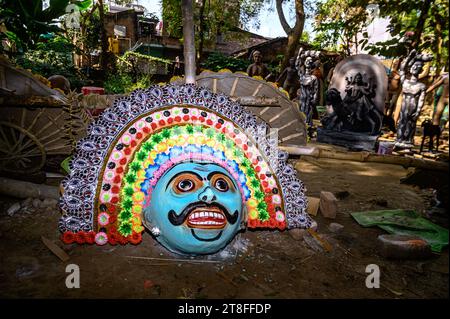 Ein Dorfidol-Künstler stellt große Farbmasken her, die Purulia Chhau Tanzmasken nachempfunden sind (Purulia Chhau Tanz ist auf der UNESCO-Liste der Tänze aufgeführt) von Göttinnen, Tieren und Rakshasas (humanoide Dämonen oder ungerechte Geister) wie hinduistische Mythologie-Charaktere aus Ton. Der Künstler malt dann mit Farbe und Verzierung die Tonmasken, die in einem Jagaddhatri Puja Pandal installiert werden. Dann tragen die Arbeiter die fertigen Masken in einem Auto in Tehatta, Westbengalen, Indien am 20.11.2023. (Foto: Soumyabrata Roy/NurPhoto) Stockfoto