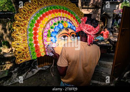 Ein Dorfidol-Künstler stellt große Farbmasken her, die Purulia Chhau Tanzmasken nachempfunden sind (Purulia Chhau Tanz ist auf der UNESCO-Liste der Tänze aufgeführt) von Göttinnen, Tieren und Rakshasas (humanoide Dämonen oder ungerechte Geister) wie hinduistische Mythologie-Charaktere aus Ton. Der Künstler malt dann mit Farbe und Verzierung die Tonmasken, die in einem Jagaddhatri Puja Pandal installiert werden. Dann tragen die Arbeiter die fertigen Masken in einem Auto in Tehatta, Westbengalen, Indien am 20.11.2023. (Foto: Soumyabrata Roy/NurPhoto) Stockfoto