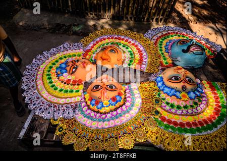 Ein Dorfidol-Künstler stellt große Farbmasken her, die Purulia Chhau Tanzmasken nachempfunden sind (Purulia Chhau Tanz ist auf der UNESCO-Liste der Tänze aufgeführt) von Göttinnen, Tieren und Rakshasas (humanoide Dämonen oder ungerechte Geister) wie hinduistische Mythologie-Charaktere aus Ton. Der Künstler malt dann mit Farbe und Verzierung die Tonmasken, die in einem Jagaddhatri Puja Pandal installiert werden. Dann tragen die Arbeiter die fertigen Masken in einem Auto in Tehatta, Westbengalen, Indien am 20.11.2023. (Foto: Soumyabrata Roy/NurPhoto) Stockfoto