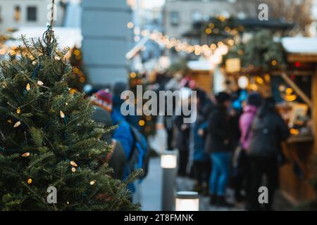 Die Käufer treffen sich auf einem lebhaften Weihnachtsmarkt mit Lichtern und saisonalen Dekorationen, der eine gemütliche Urlaubsatmosphäre in Quebec, Kanada, schafft Stockfoto