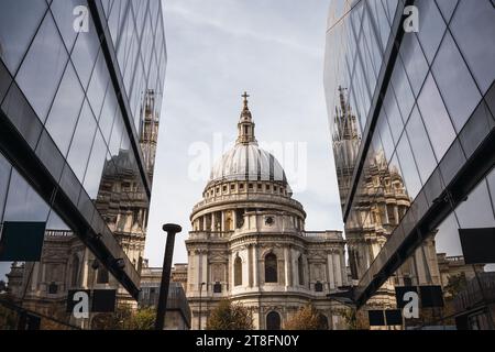 St. Paul's Cathedral in London spiegelte sich anmutig auf den Glasfassaden der umliegenden modernen Gebäude unter einem bewölkten Himmel. Stockfoto