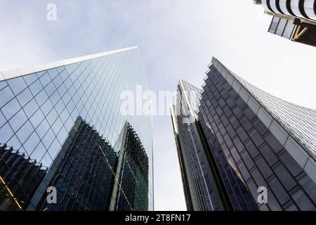 Ein flacher Blick auf moderne Glashochhäuser, die sich in Richtung eines klaren blauen Himmels in Londons dynamischem Stadtbild erstrecken. Stockfoto