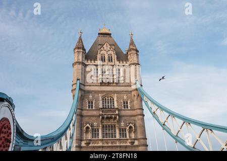 Nahaufnahme von Londons berühmter Tower Bridge unter einem klaren blauen Himmel mit architektonischen Details und einem einsamen Vogel, der vorbeifliegt. Stockfoto