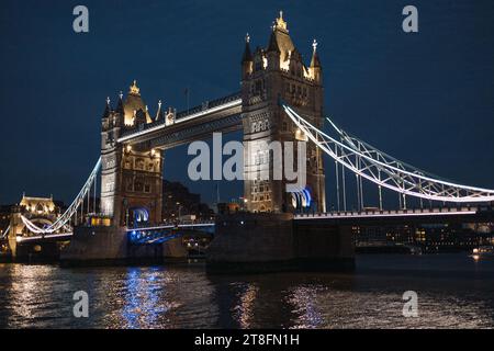 Die berühmte Tower Bridge in London wurde bei Nacht mit ihren Lichtern aufgenommen, die von der Themse reflektieren und die Schönheit des historischen Bogens der Stadt zeigen Stockfoto