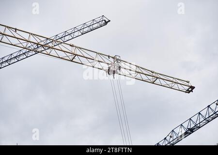 Mehrere hohe Baukräne gegen einen klaren blauen Himmel. Baukran mit Kabine zur Kransteuerung mit Kopierraum. Hochwertige Fotos Stockfoto