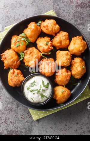 Hausgemachte Deep Fried Hush Puppy Corn Fritters Nahaufnahme auf dem Teller auf dem Tisch. Vertikale Draufsicht von oben Stockfoto