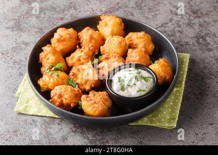 Still Welpen frittierte Maismehlbällchen aus Zwiebeln, Knoblauch und Butter auf dem Teller auf dem Tisch. Horizontal Stockfoto