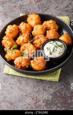 Hush Welpen, Südstaatenfutter, frittierte Maisbrotbällchen aus der Nähe auf dem Teller auf dem Tisch. Vertikal Stockfoto