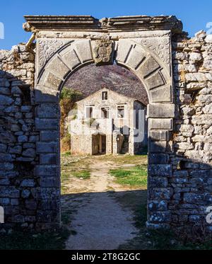 Ruine des Schulhauses und des Bogens im teilweise verlassenen Dorf Alte Perithia (Palea Perithea) auf den hohen Hängen des Pandokratoras in Korfu Griechenland Stockfoto