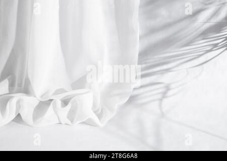 Weicher, gefalteter Vorhang mit Palmenblättern, Schatten auf weißem Hintergrund, leerer Hintergrund Stockfoto