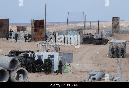 Israelische Infanterie-Soldaten der 55. Brigade von Fallschirmjägern mit leichten Waffen, während sie am 20. November 2023 in einer Feuerübung vor der Tze'elim-Basis in Süd-Israel in der Nähe der Grenze zum Gazastreifen trainieren, zusammen mit Merkava-Panzern des Panzerkorps. Der Soldat übt die Evakuierung eines verwundeten Kameraden auf einer Bahre. Die Soldaten sind alle Reservetruppen der IDF und waren noch nicht im Gazastreifen. Einige der Soldaten kehrten nach dem Terroranschlag der Hamas auf südliche israelische Gemeinden am 7. Oktober 2023 sofort aus dem Ausland nach Israel zurück. Foto von Jim Hollander/UPI Stockfoto