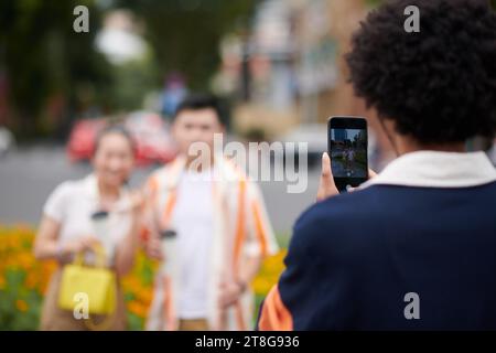 Mann, der Touristen auf dem Smartphone fotografiert Stockfoto