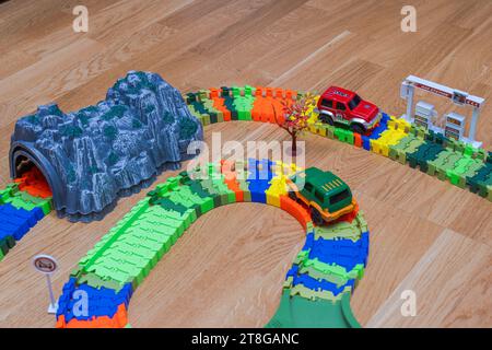 Nahansicht der Click-Click-Straße für eine lebendige Miniatur-Spielzeugbahn auf Holzboden. Stockfoto