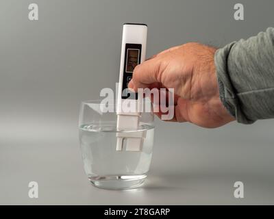 Wasserqualitätsprüfer auf grauem Hintergrund. Gerät zur Messung der Wasserqualität. Stockfoto