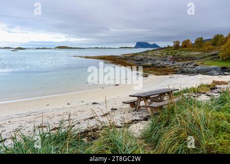 Grillplatz am Atlantikufer in der Nähe von Sommarøy, Norwegen. Sandstrand mit Grill, Parkbank und Entspannungsbereich, am türkisfarbenen Meer wie Karibik Stockfoto