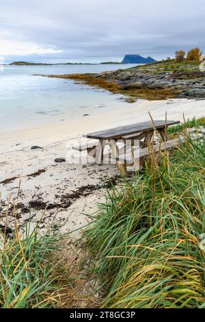 Grillplatz am Atlantikufer in der Nähe von Sommarøy, Norwegen. Sandstrand mit Grill, Parkbank und Entspannungsbereich, am türkisfarbenen Meer wie Karibik Stockfoto