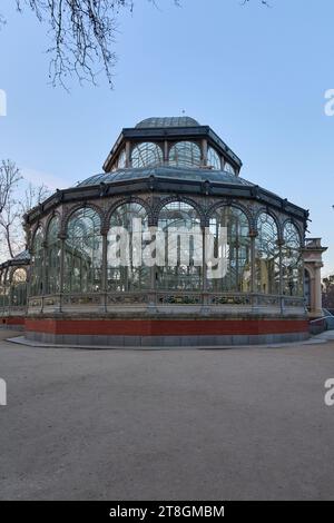 Viktorianischer Glaspavillon in einem Park in der Abenddämmerung, der das Dämmerungslicht reflektiert. Stockfoto