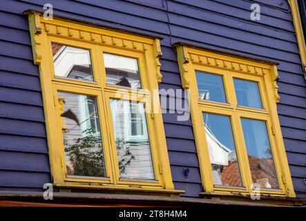 Stavanger, ventanas con sus reflejos en una de las casas de colores brillantes, azul y amarillo, en la calle Øvre Holmegate o Fargegaten, Noruega Stockfoto