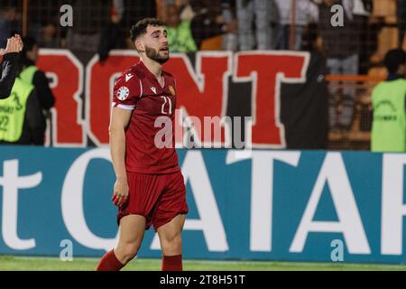 Ein Fußballspieler wird vom Spielfeld abgehängt und mit einem breiten Lächeln auf die jubelnde Menge im Hintergrund reagiert Stockfoto