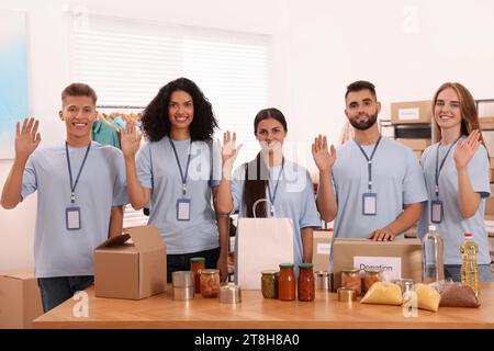 Porträt von Freiwilligen und Lebensmitteln am Tisch im Lager Stockfoto