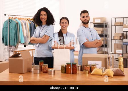 Porträt von Freiwilligen und Lebensmitteln am Tisch im Lager Stockfoto