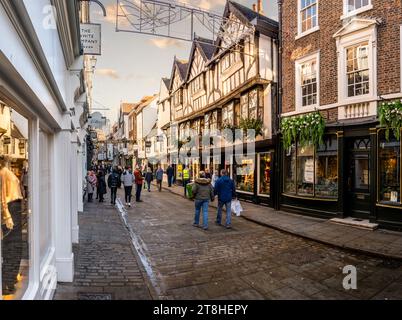 STONEGATE, YORK, GROSSBRITANNIEN - 17. NOVEMBER 2023. Shopper und Menschenmassen laufen durch die Einkaufsstraße Stonegate mit Einzelhandelsgeschäften wie dem Kat Stockfoto