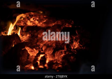 Feuer im Herd. Flammenstruktur. Brennende Kohlen. Hohe Temperatur. Brennholz. Stockfoto