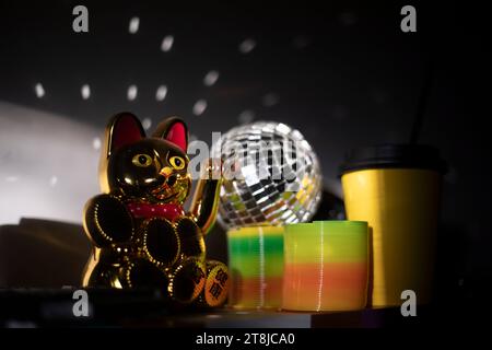 Chinesische Katze Bringt Glück. Artikel im Regal. Blendung von Licht auf Objekten. Goldfarbenes Spielzeug. Stockfoto