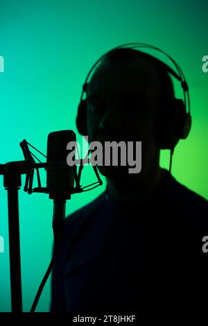 Voiceover Artist Voice Actor in Vocal Recording Studio mit großen Membran Mikrofon und Anti-Pop-Schild. Stockfoto