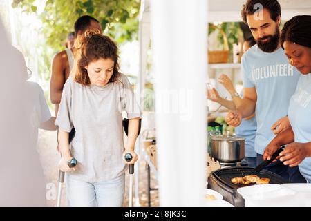 afroamerikanische und kaukasische Freiwillige helfen den Benachteiligten, indem sie kostenlose Lebensmittel verteilen. Die gemeinnützige Gruppe bietet Obdachlosen, Behinderten, Kranken und Bedürftigen Hungerhilfe. Stockfoto