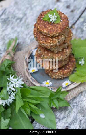 selbstgemachte Kräuterpasteten mit wildem Knoblauch auf einem Teller, dekoriert mit Gänseblümchen Stockfoto